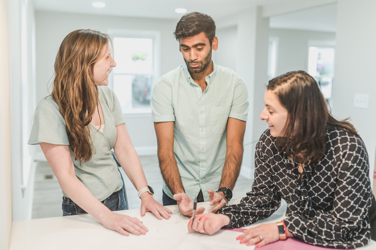 Three adults having a discussion about real estate in a modern home setting.